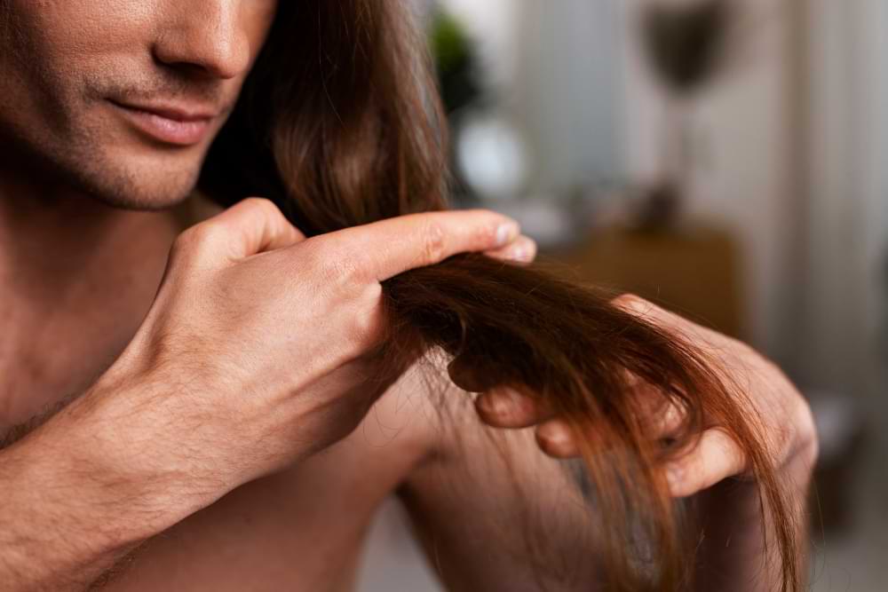 man will langes haar mit fingern abschneiden.jpg