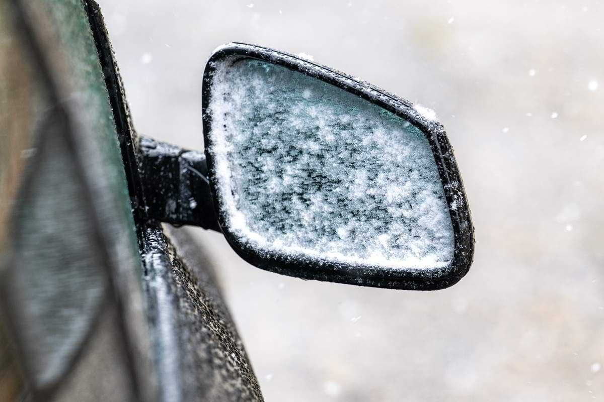 Schnee haftet am Außenspiegel eines Autos.jpeg