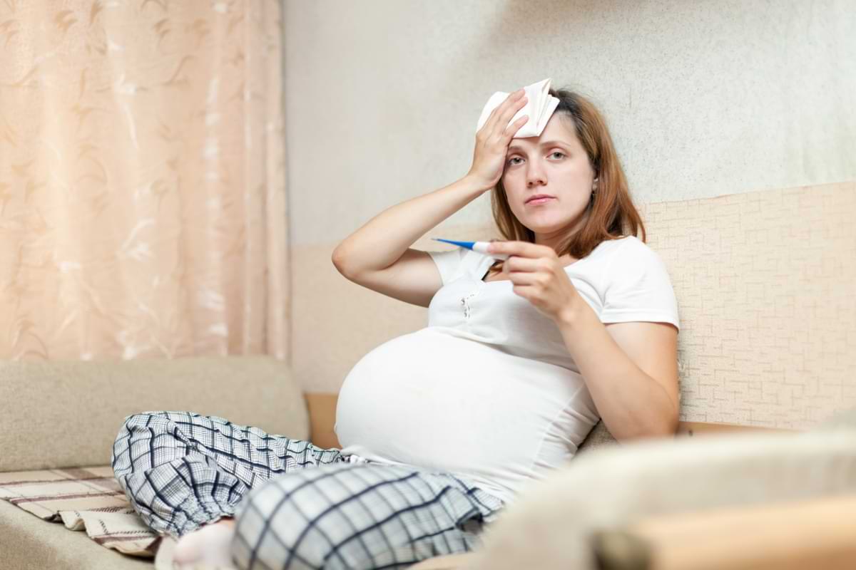 Schwangere Frau misst Fieber Temperatur.jpg