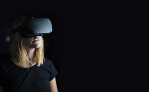 blonde frau mit vr brille in dunklem raum.jpg