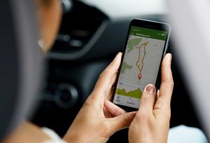 frau im auto verfolgt tracking route im smartphone mit karten app.jpg