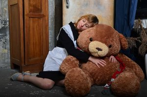 junge frau die mit riesen teddybär kuschelt und knuddelt.jpg