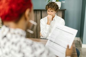 büro man bei vorstellung frau sieht dokument an.jpg