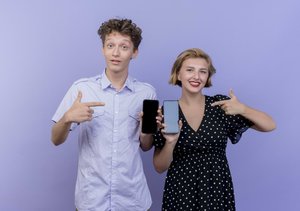 junge frau und man zeigen ihre smartphones im vergleich.jpg